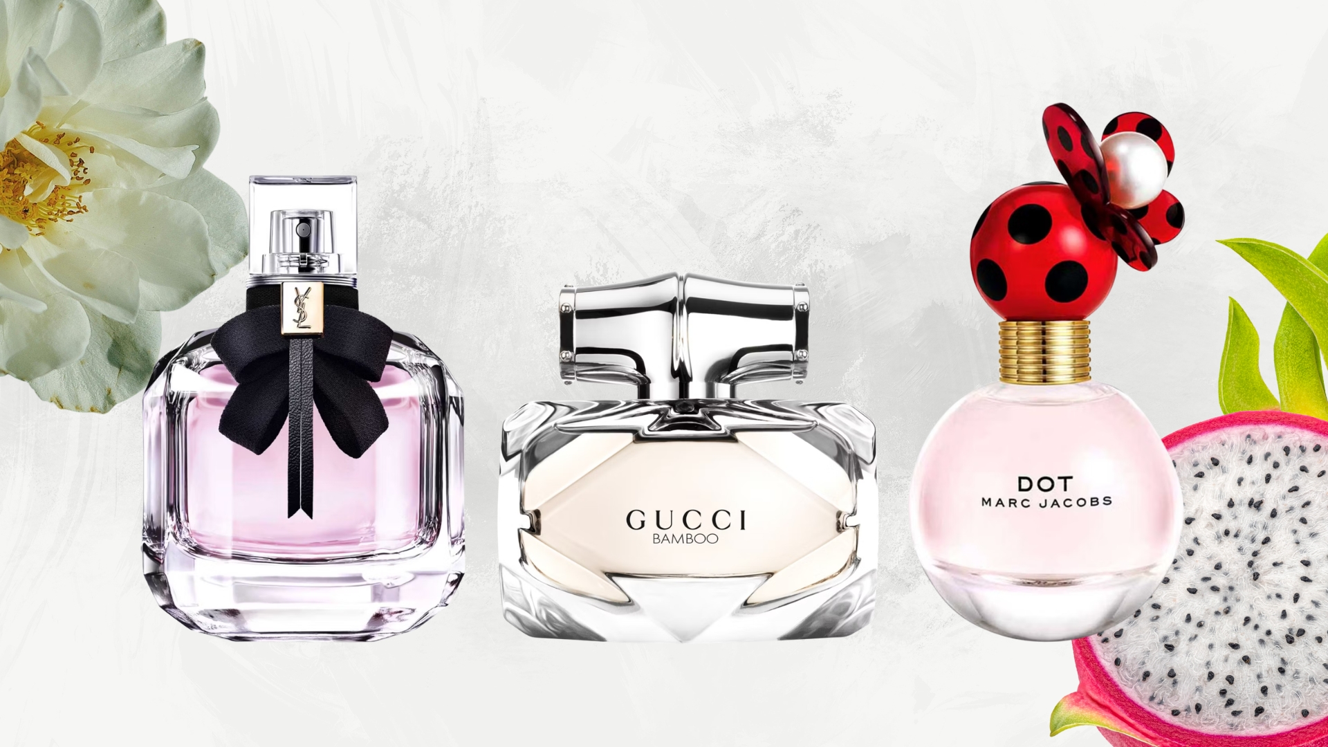 Lineup of luxury perfumes in Boots payday sale (L-R) YSL Mon Paris, Gucci Bamboo and Marc Jacobs Dot, on a white background with white flower and pink dragonfruit
