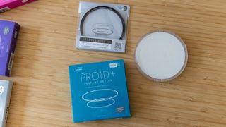 The Kenko PRO1D+ UV filter next to the box and adapter ring
