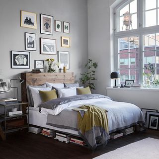 bedroom with grey wall and bed with cushions