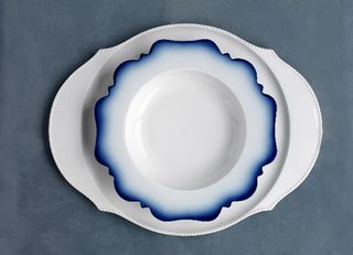 A white dish with blue around the intricately-shaped edge