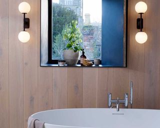 twin mid century modern style lights in a bathroom above a freestanding bath - Astro at Dusk Lighting