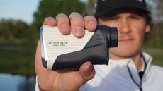 The Gogogo ZeroIn Vpro Rangefinder held in the hand of a golfer