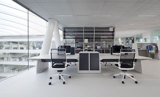 office desks inside the adidas hq, with light grey floor, white desks and chairs