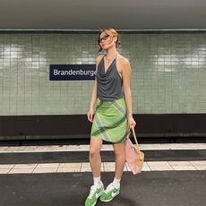 vivian wears green skirt and green sneakers with gray halter neck top 