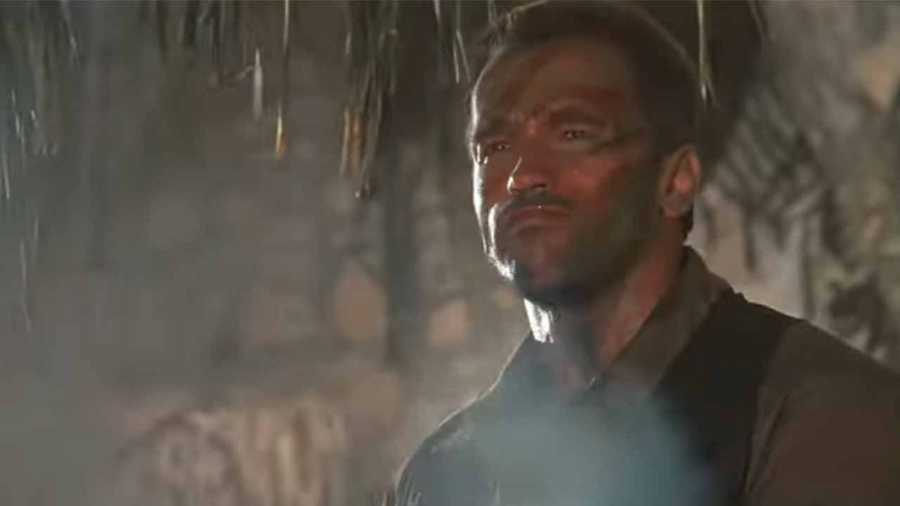 Arnold Schwarzenegger with smoke in front of him in Predator.