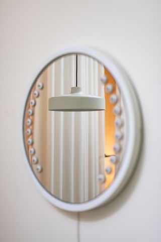 Momo Skin Studio interior mirror and hanging white pendant light