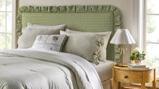 Light gray bedroom featuring a bed styles with a green gingham ruffle-bordered headboard and pinstriped bedding