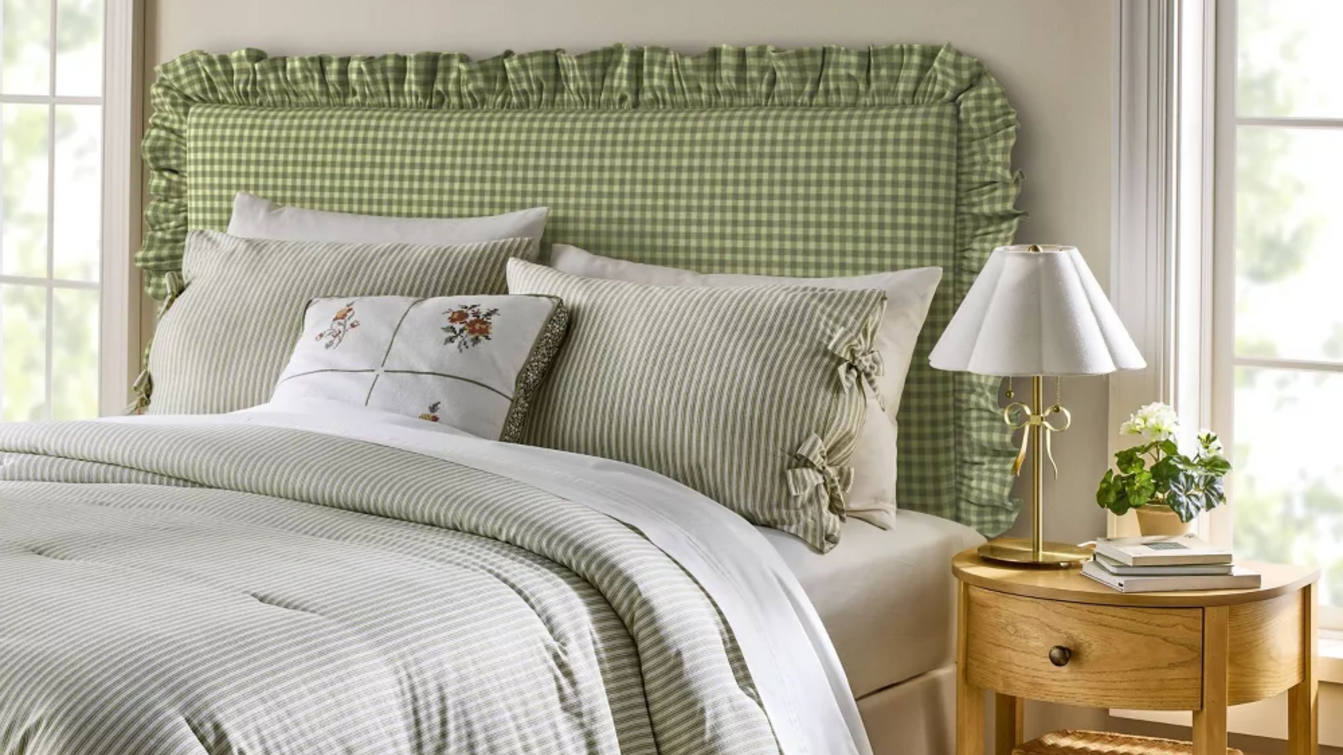Light gray bedroom featuring a bed styles with a green gingham ruffle-bordered headboard and pinstriped bedding