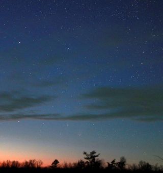 Comet Pan-STARRS in conjunction with the great Andromeda Galaxy, M31, on April 4, 2013. The objects appear just above the setting sun.