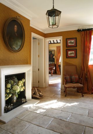 ochre hallway with fireplace, stripe curtains and natural stone floor