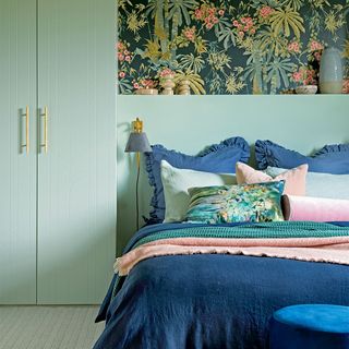 bedroom with green wardrobes and dark floral wallpaper