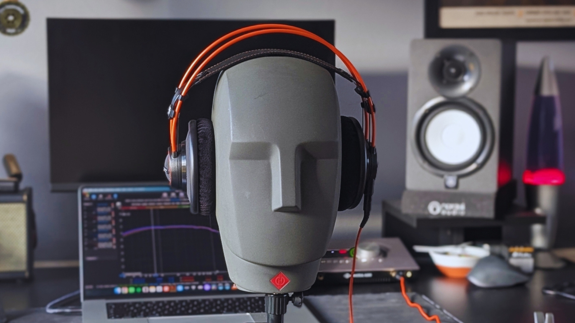 A pair of AKG K712 Pro headphones on a Neumann KU 100 dummy head