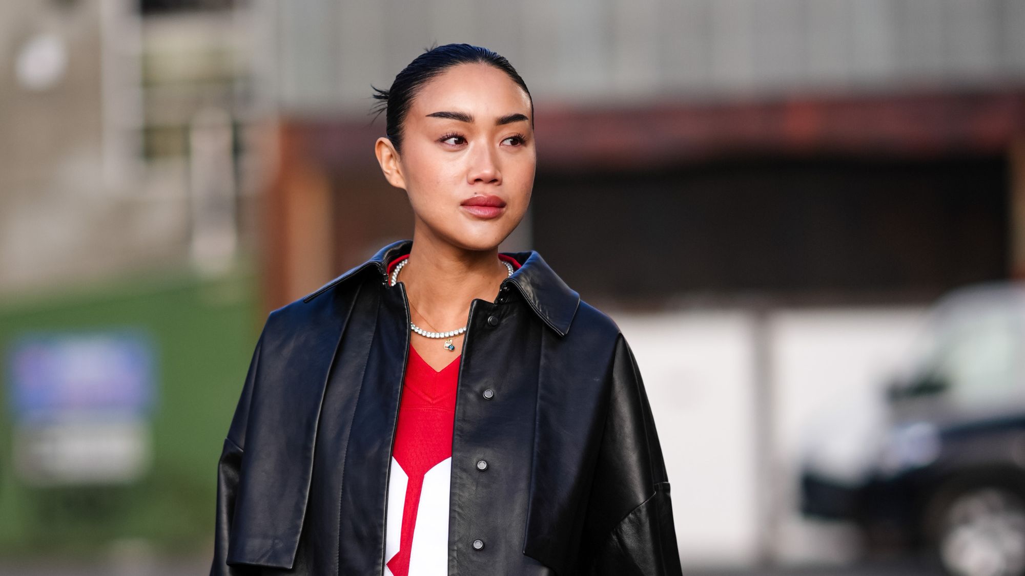 best foundations for oily skin - street style shot of woman with a sleek bun and leather jacket