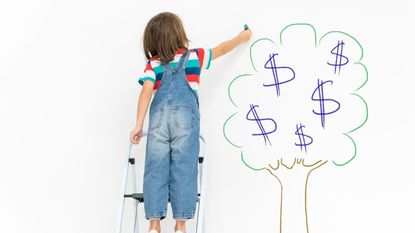 Child on ladder and chalk money tree drawing on living room wall