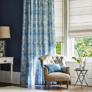 Bay window with blue floral curtains and cream blinds