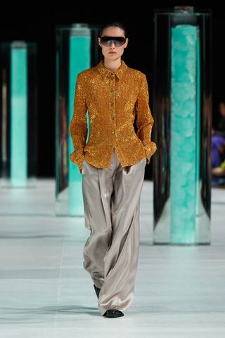 Woman on Stiney goya runway in sequin shirt and silky wide-leg trousers