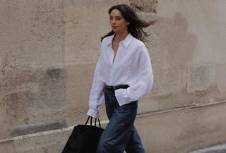 fashion influencer @modadamour wearing a white button-down shirt with barrel jeans