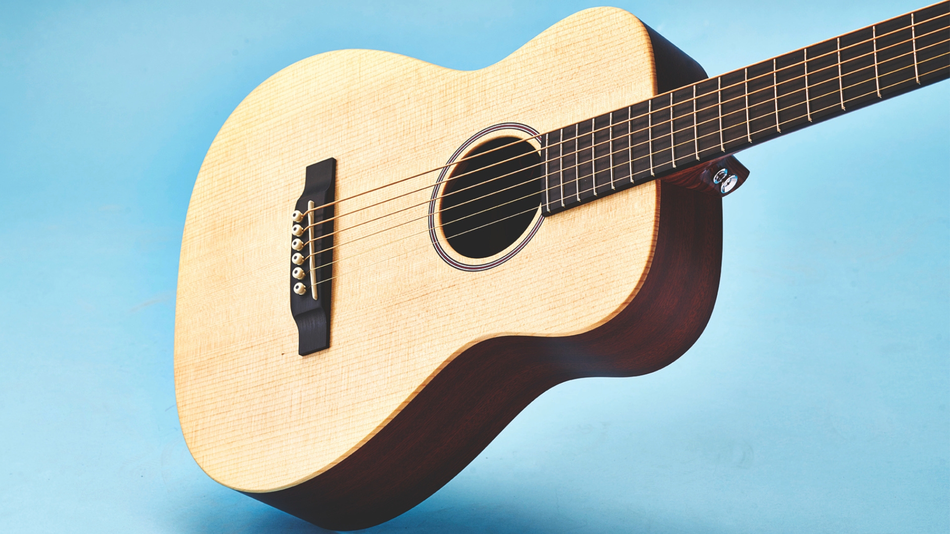 A Martin LX1 Little Martin acoustic guitar on a light blue background