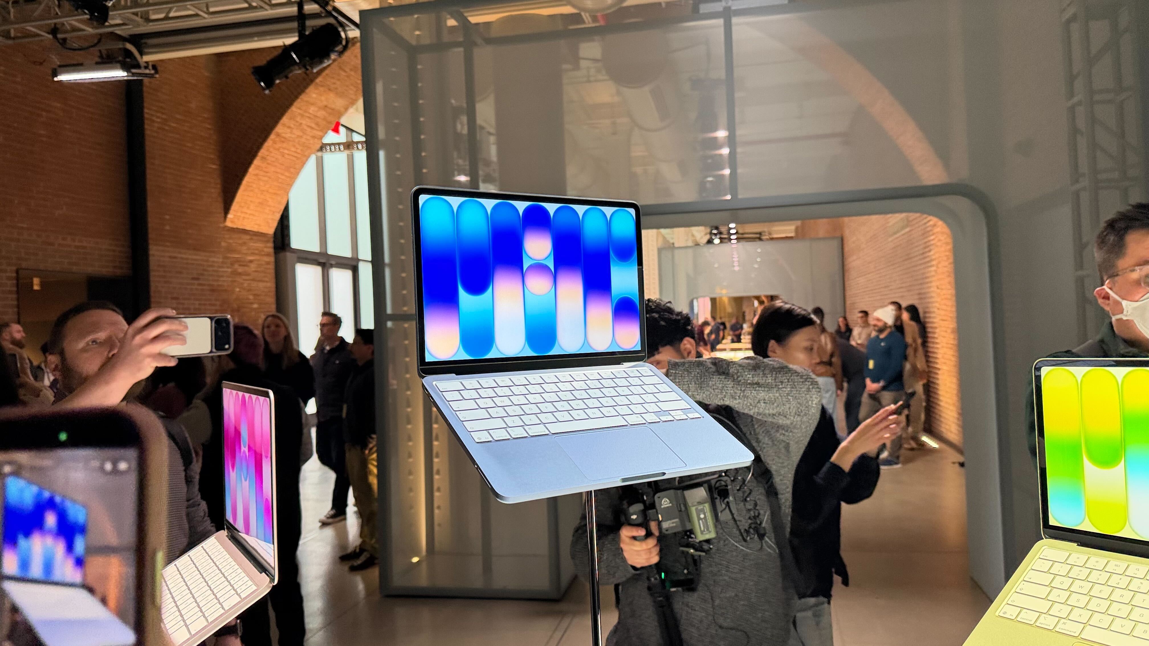 macbook neo on display at apple event in yellow and blue