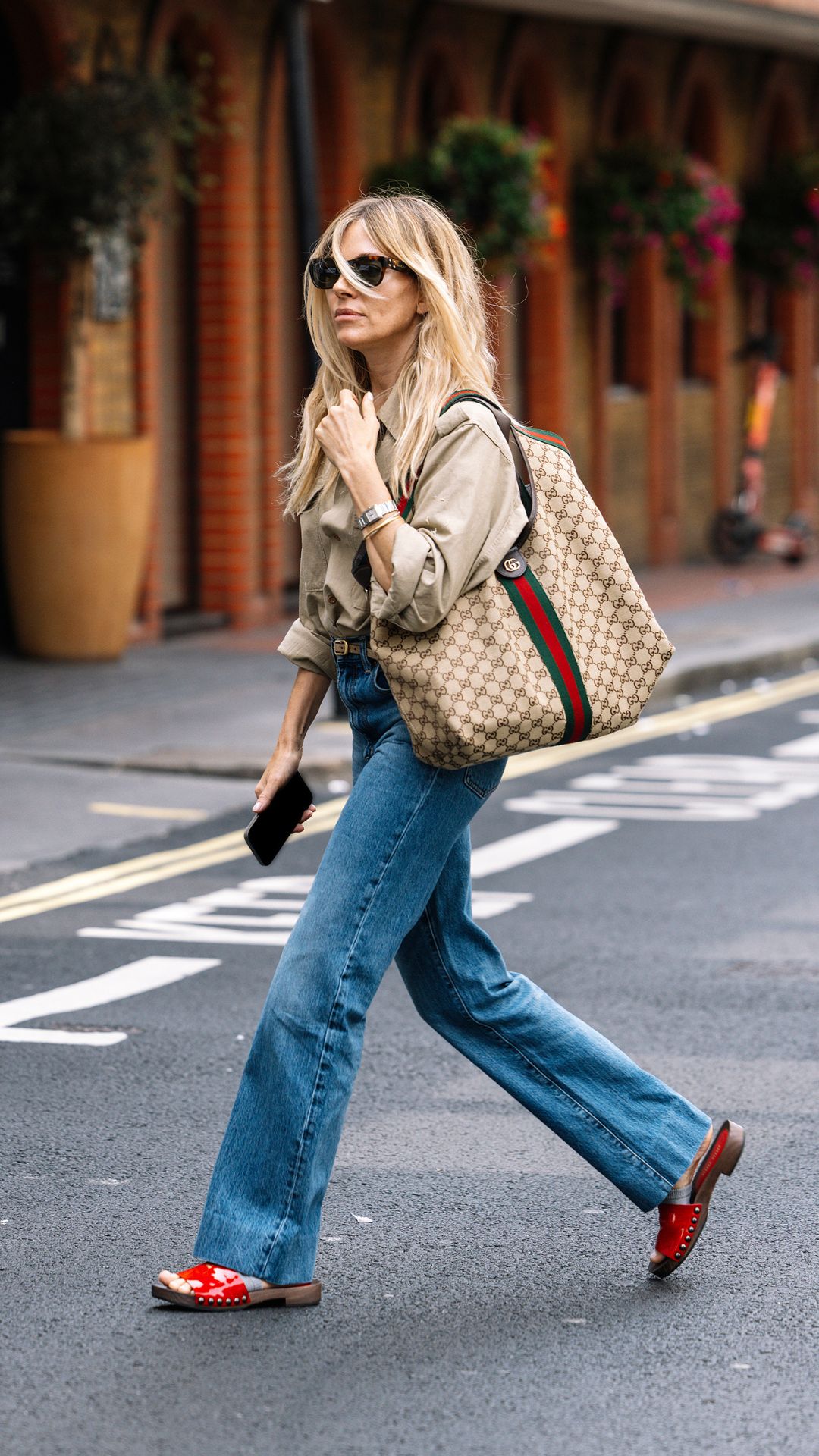 SIENNA MILLER WEARING A SHIRT AND WIDE LEG JEANS
