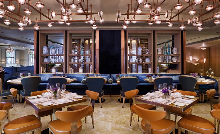 Dining area with taupe leather seating, bronze light fixtures and highlights of blue