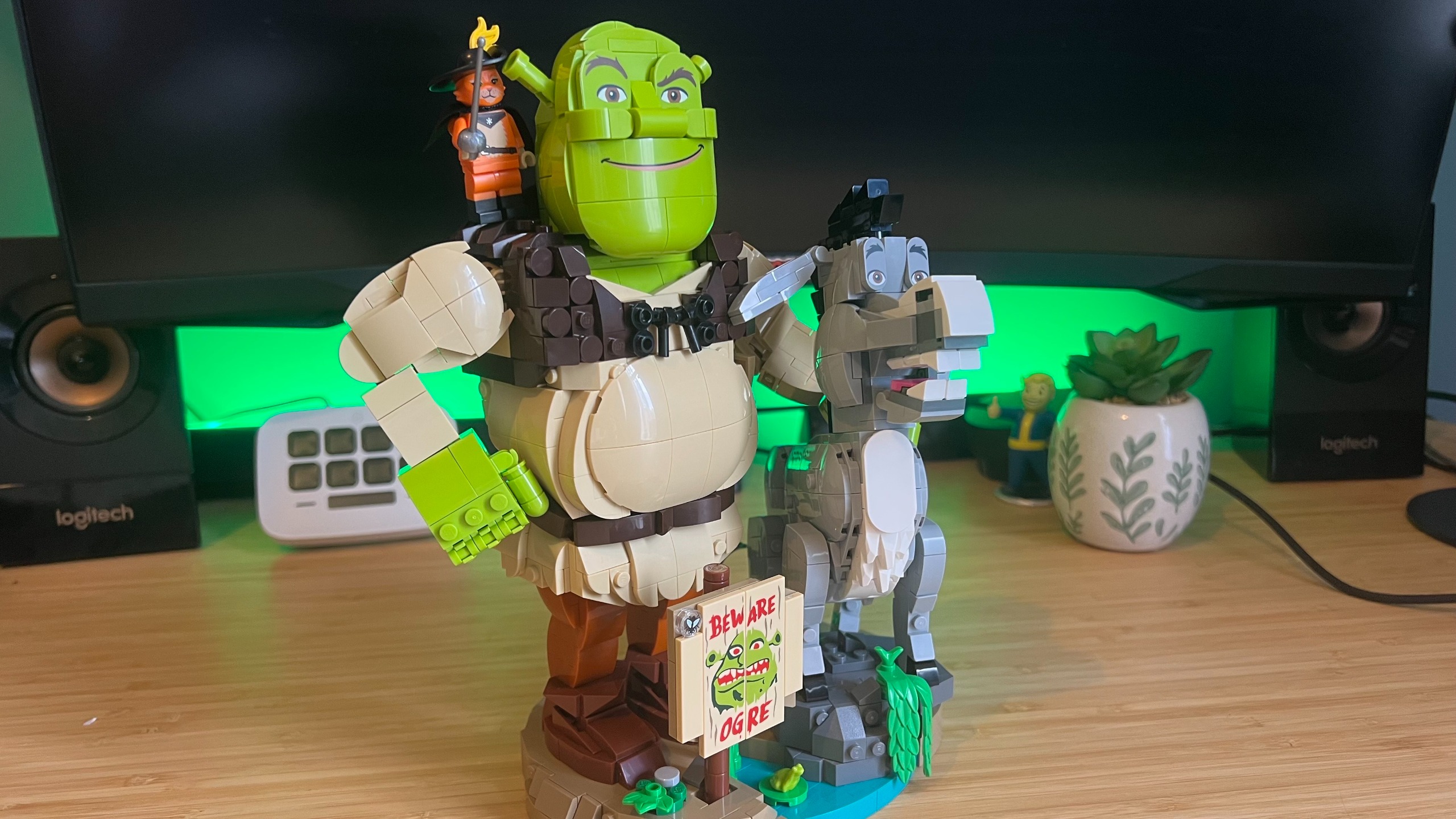 Lego Shrek, Donkey &amp; Puss in Boots set on a wooden desk with green backlighting
