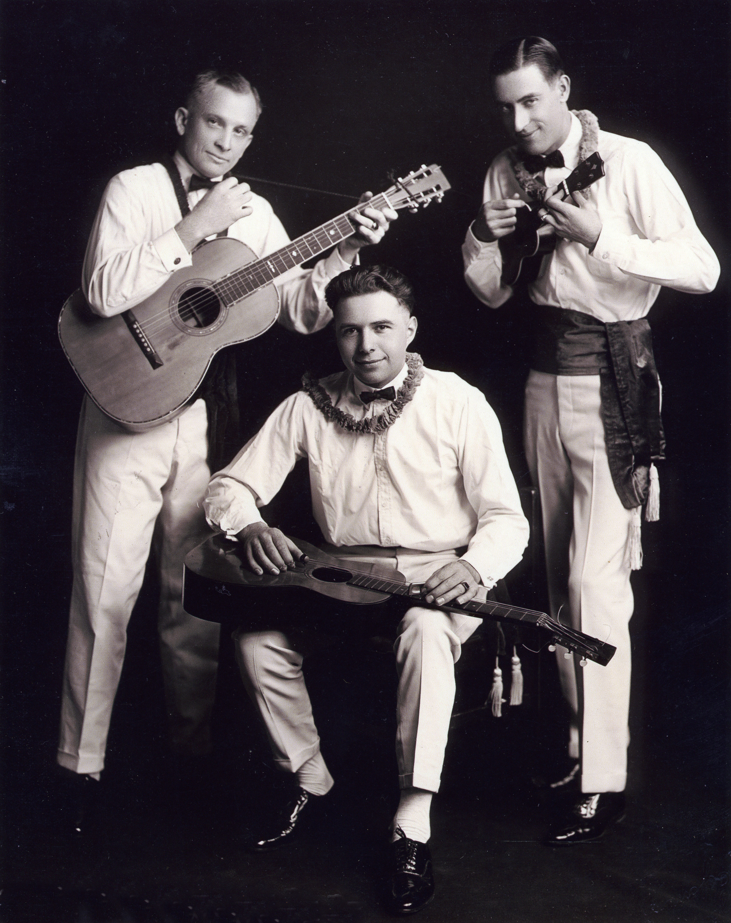 A promotional photo of the Waikiki Trio. The standing guitarist is playing a Martin 0-42, and the seated guitarist is playing a Martin 0-18K.