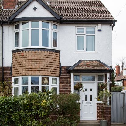house exterior with white and bricked wall and white window and door
