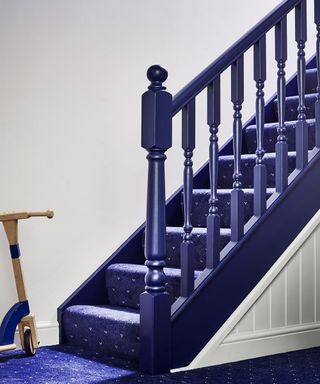 Royal blue rossini patterned carpet with matching blue painted banister