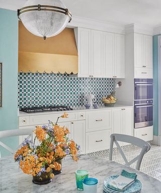 kitchen with blue and white tiles and white cabinets