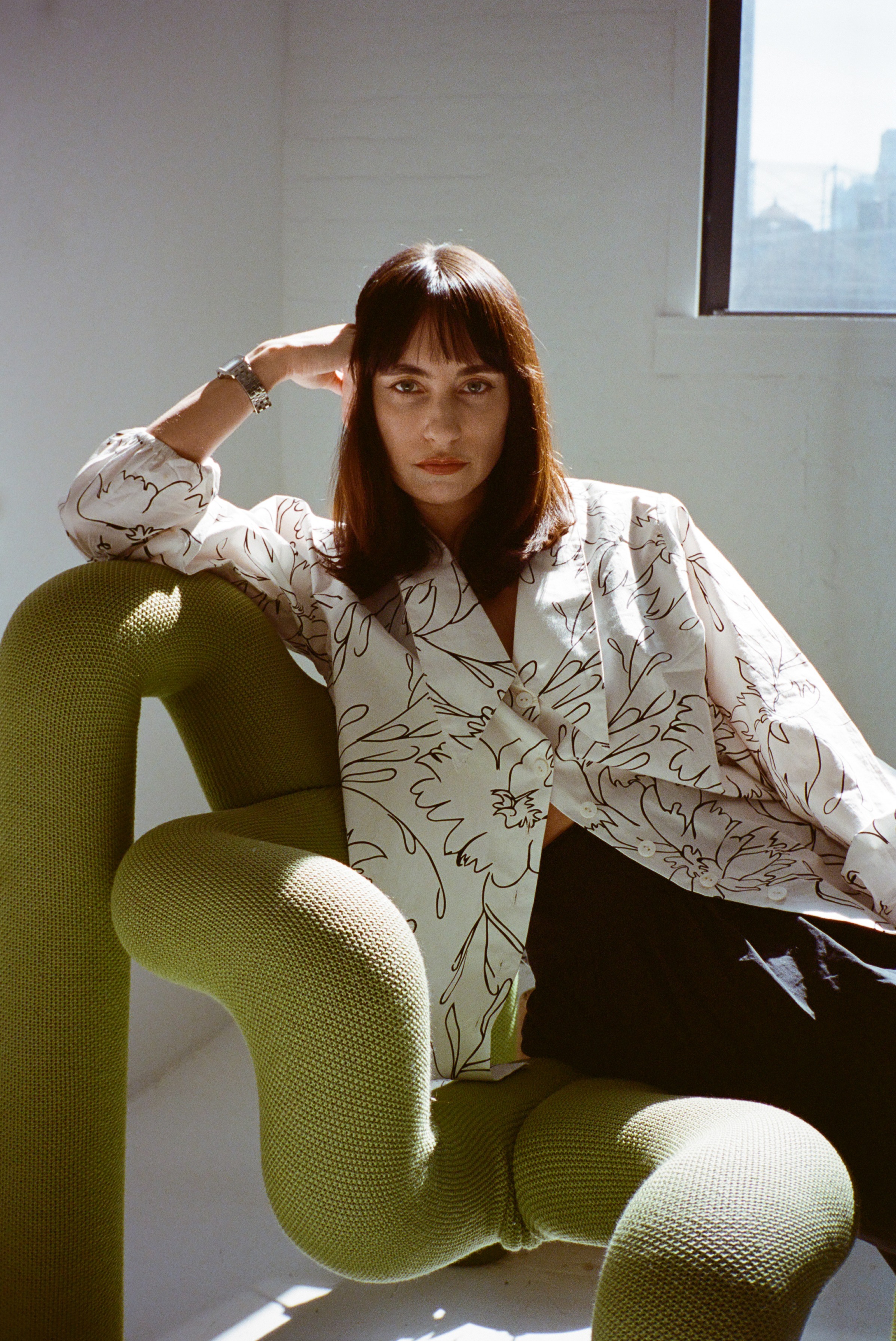 Wray Serna sits on a chair in her design studio