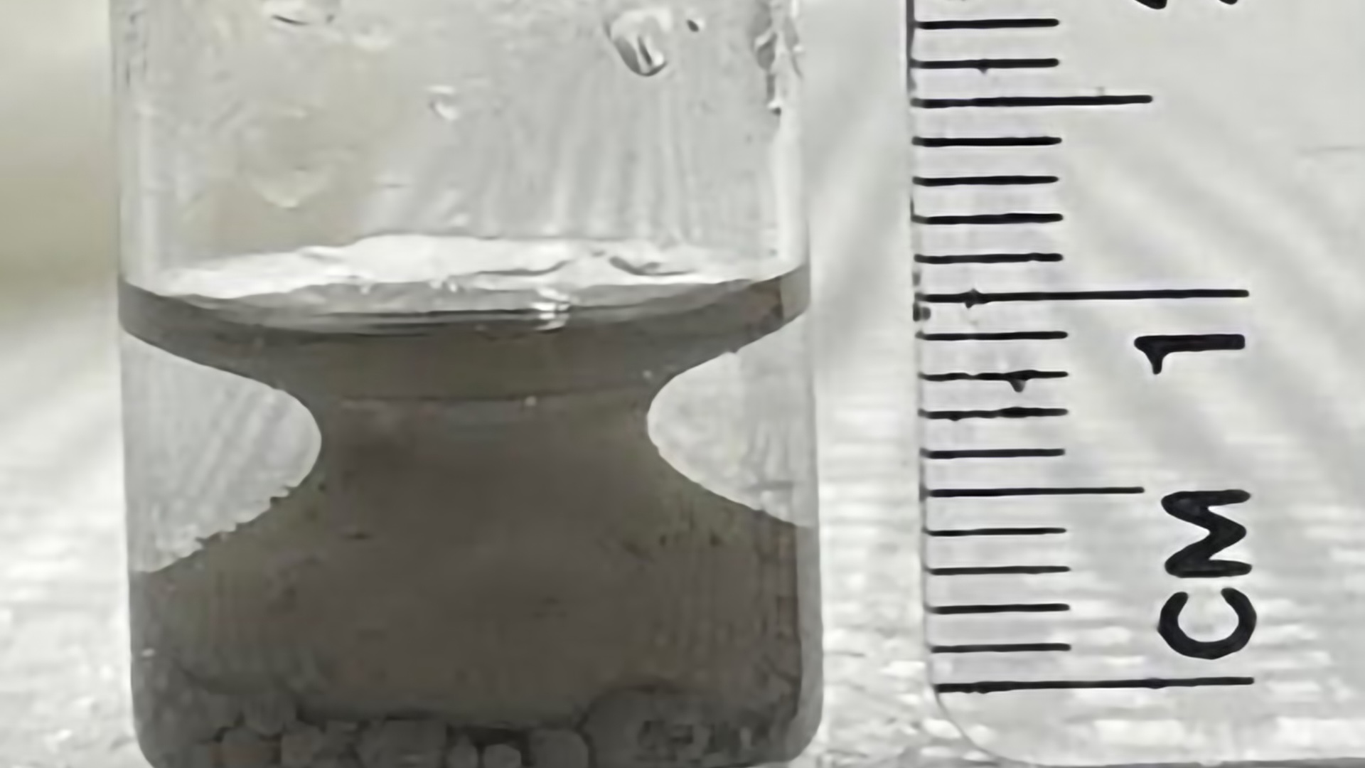 a close-up of a material that forms a shape like a Grecian urn in a test tube
