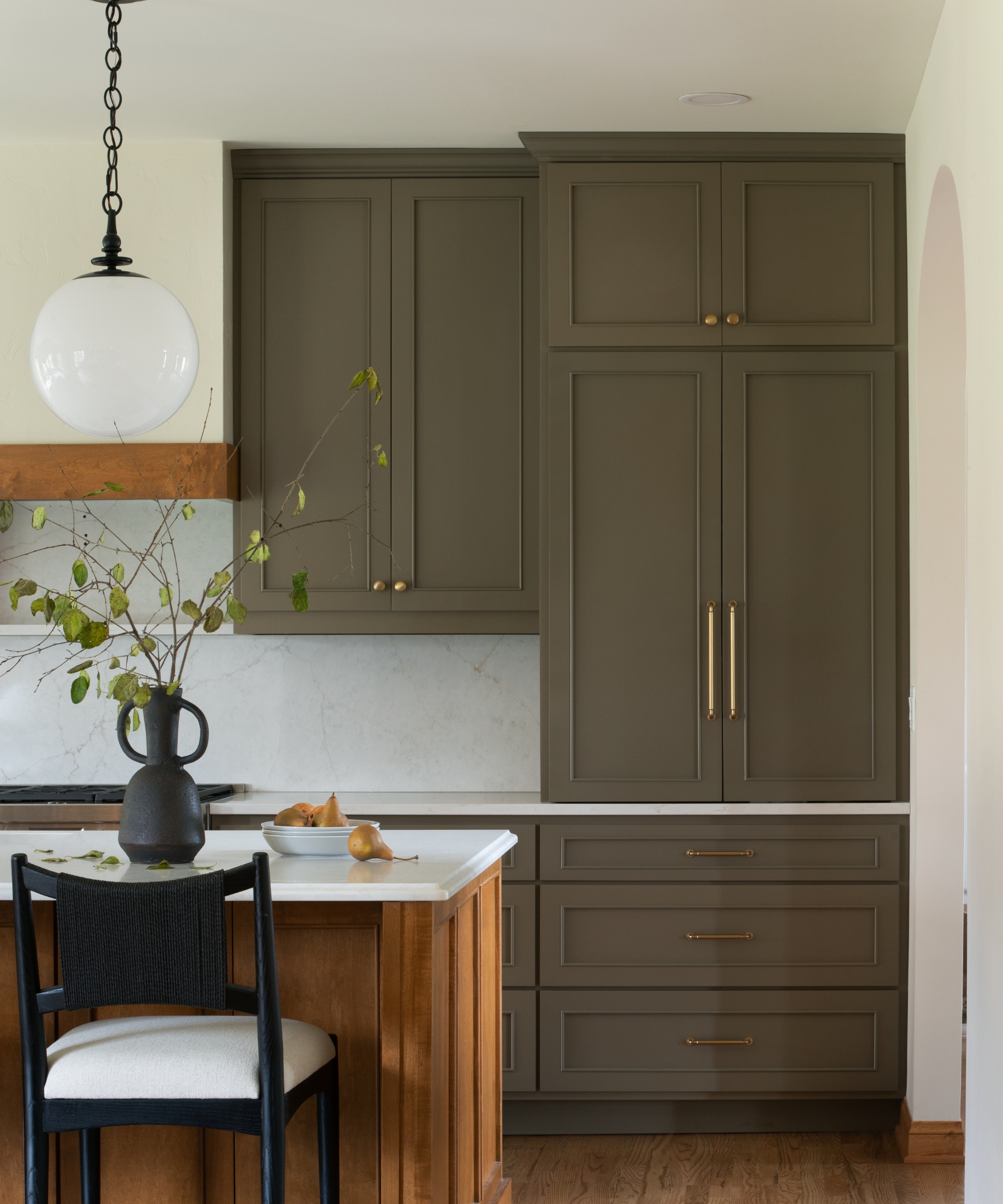 a kitchen with dark olive cabinets and a wooden island