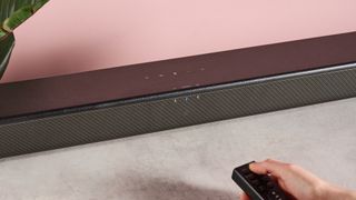 Person turning on Sony HT-SF150 using remote