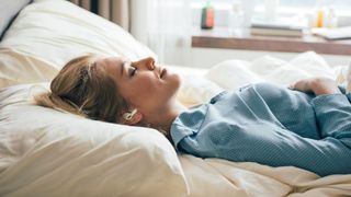 Woman sleeping with fan on and headphones in