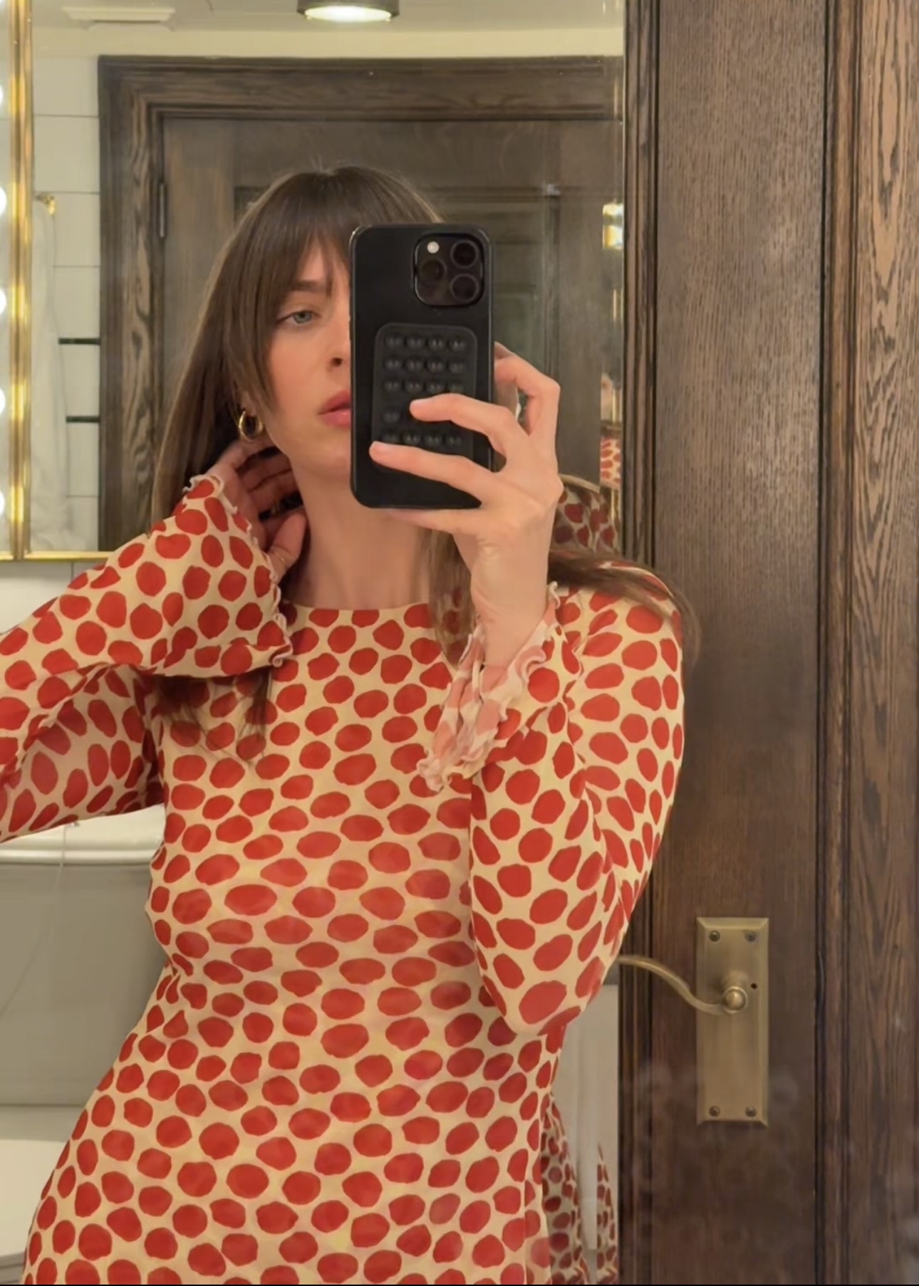 Kathryn Zahorak posing in mirror wearing red polka dot dress