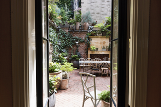 a view through the double doors onto an urban patio with furniture and patio plants