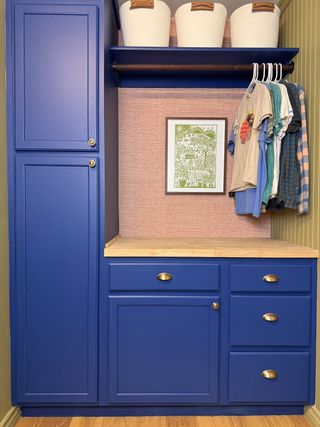 A laundry room with dark blue cabinetry