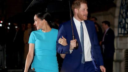 Prince Harry and Meghan Markle in March 2020 under an umbrella together