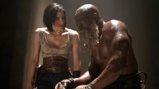 Kora (Sofia Boutella) standing behind Titus (Djimon Hounsou) in Rebel Moon - Part One: A Child of Fire
