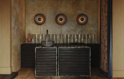 A kitchen with large, architectural wall lights