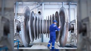 What is thermodynamics_Engineer inspecting steam turbine blades in repair bay of workshop_Monty Rakusen via Getty Images