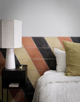 An example of headboard ideas showing a beige, orange and black tiled headboard