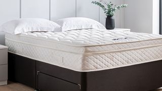 The Premier Inn mattress placed on a black divan and dressed with two simple white pillows