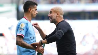 Manchester City manager Pep Guardiola gives instructions to Joao Cancelo during the Premier League match between Manchester City and Manchester United at the Etihad Stadium in Manchester, United Kingdom on 2 October, 2022.