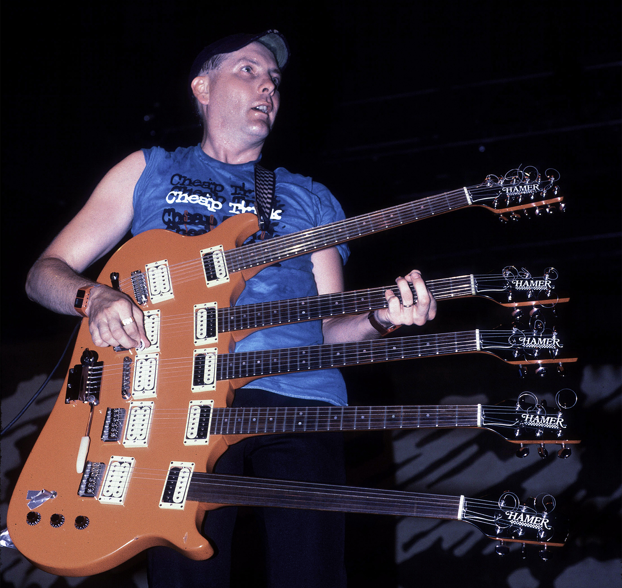 American musician Rick Nielsen plays a five-necked guitar with the band Cheap Trick during a performance onstage, Chicago, Illinois, June 15, 1990.