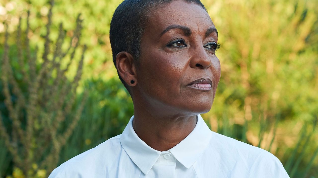 Adjoa Andoh wearing white shirt in front of plants