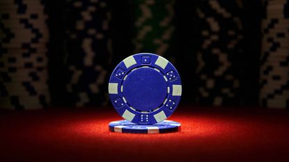 a blue poker chip on a red felt table representing the best blue chip dividend stocks to buy