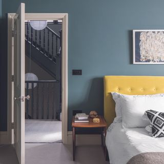 Yellow headboard in grey bedroom