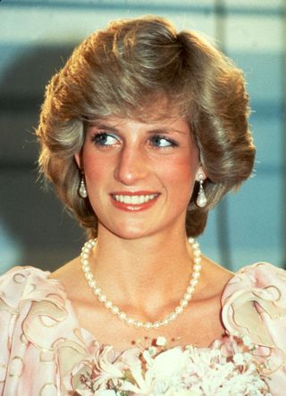 Diana, Princess of Wales, wearing a pink dress designed by Catherine Walker and a pearl necklace, smiles as she attends a gala concert at the Melbourne Concert Hall on April 14, 1983 in Melbourne, Australia.